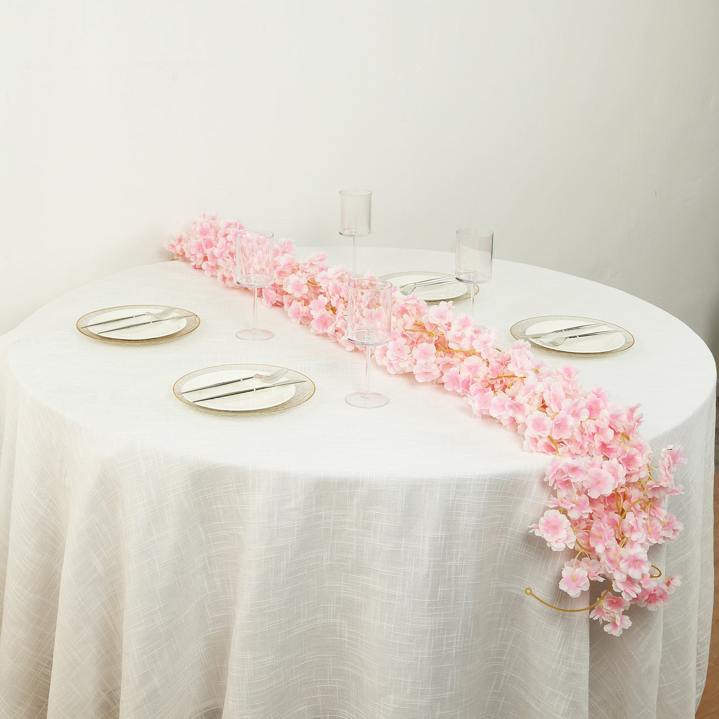 Blush artificial cherry blossom garland on a table setting.