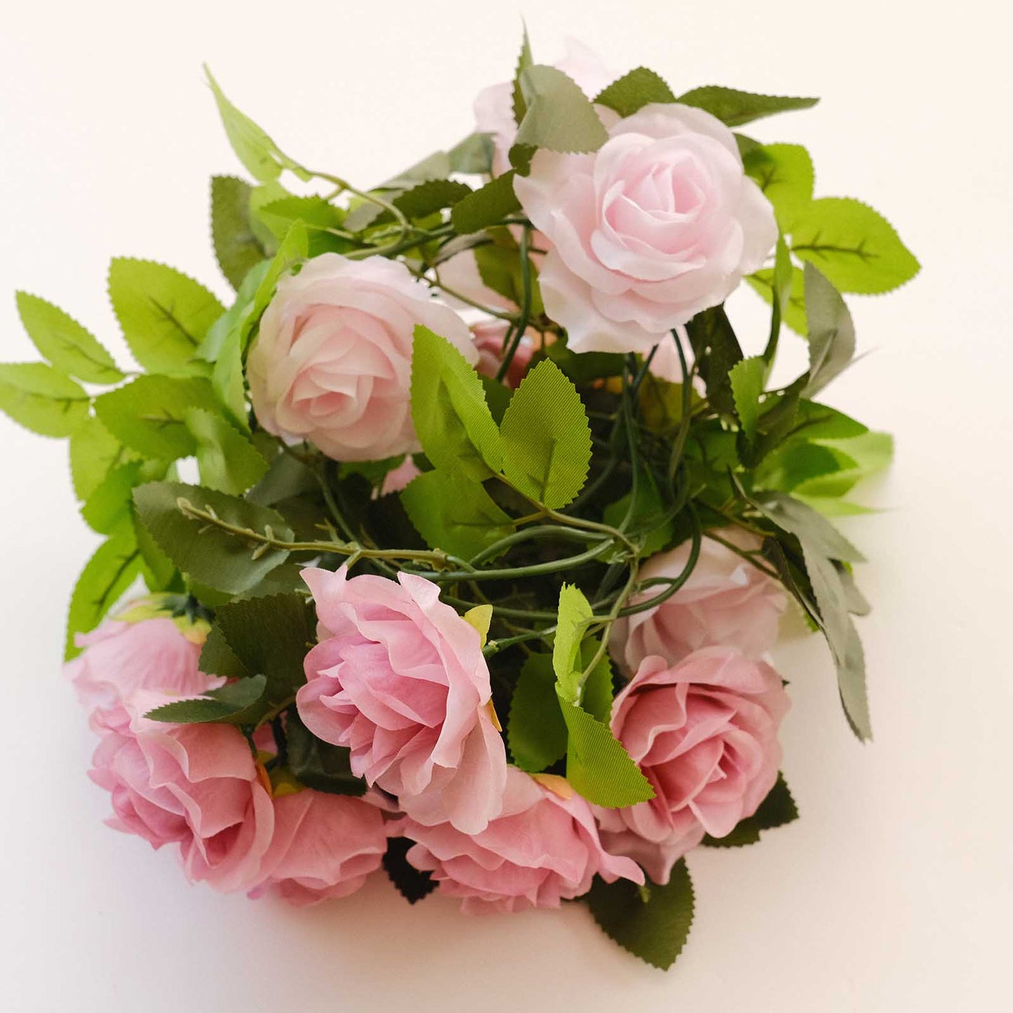 Blush pink artificial silk flower garland with mini rose vines and green leaves. #whtbkgd