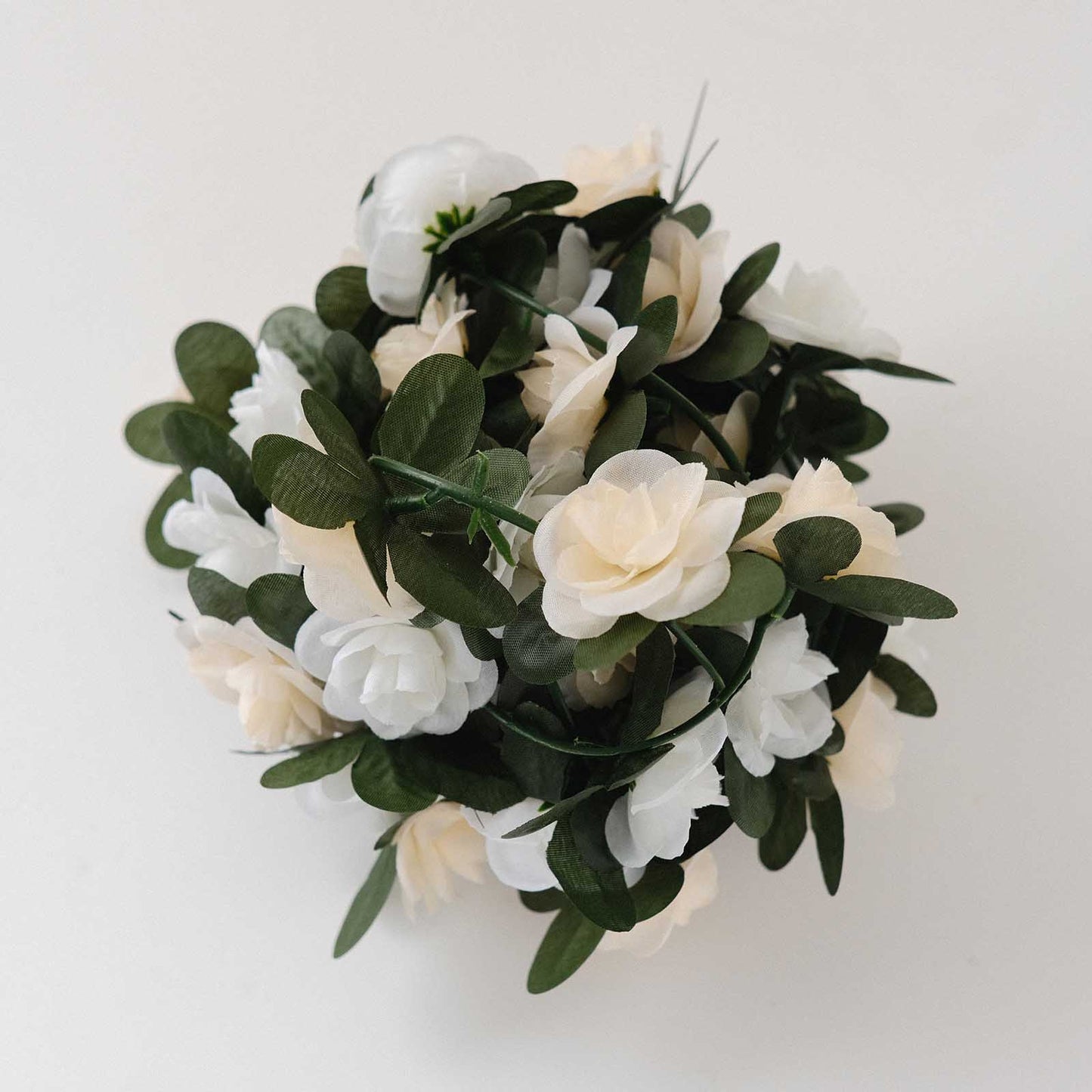 Cream ivory artificial silk flower garland with mini rose vines and green leaves.