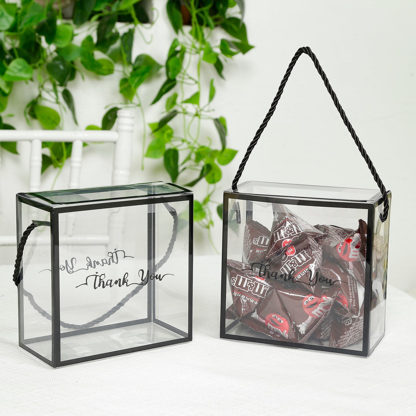 Clear PVC gift boxes with black edge handles, filled with candy and a thank you print.