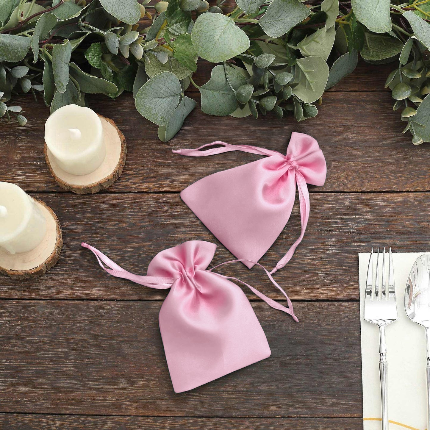 Pink satin drawstring favor bags for weddings and parties.