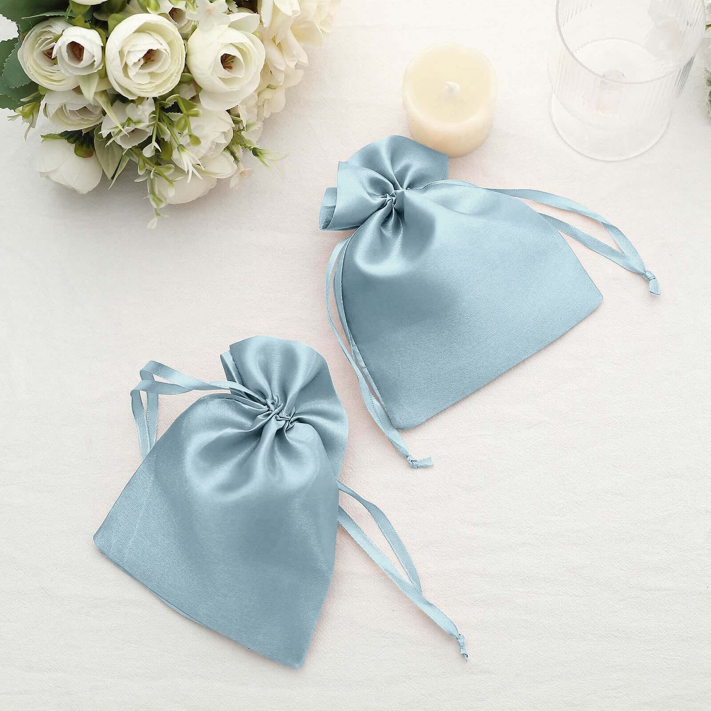 Dusty blue satin drawstring gift bags for weddings and parties.