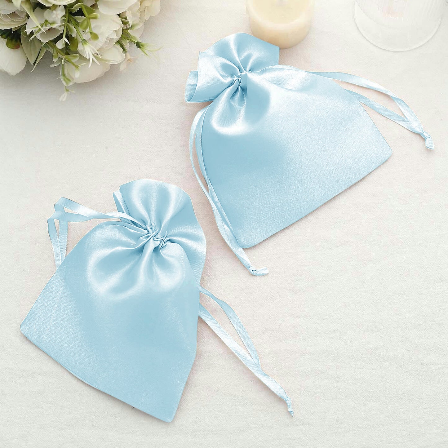 Light blue satin drawstring gift bags for wedding party favors.