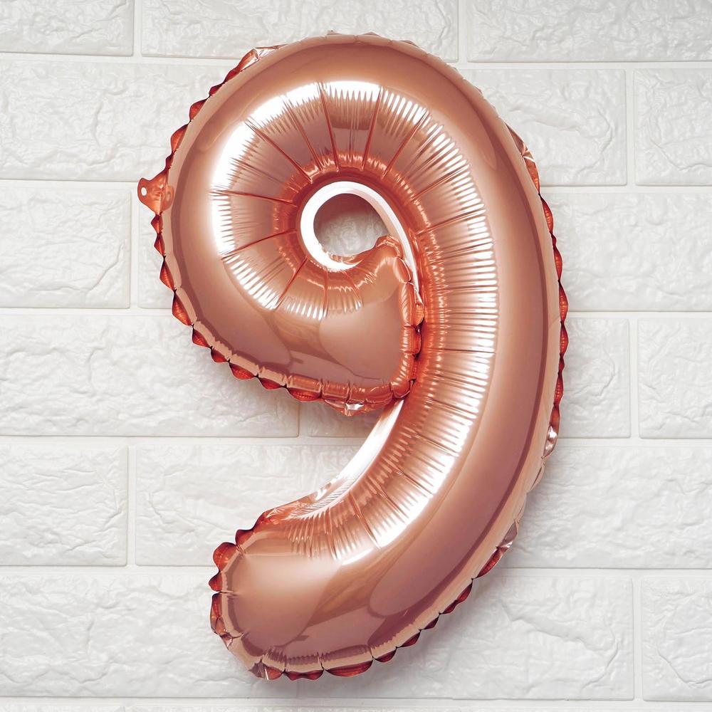 Rose gold number 9 balloon on a white background.