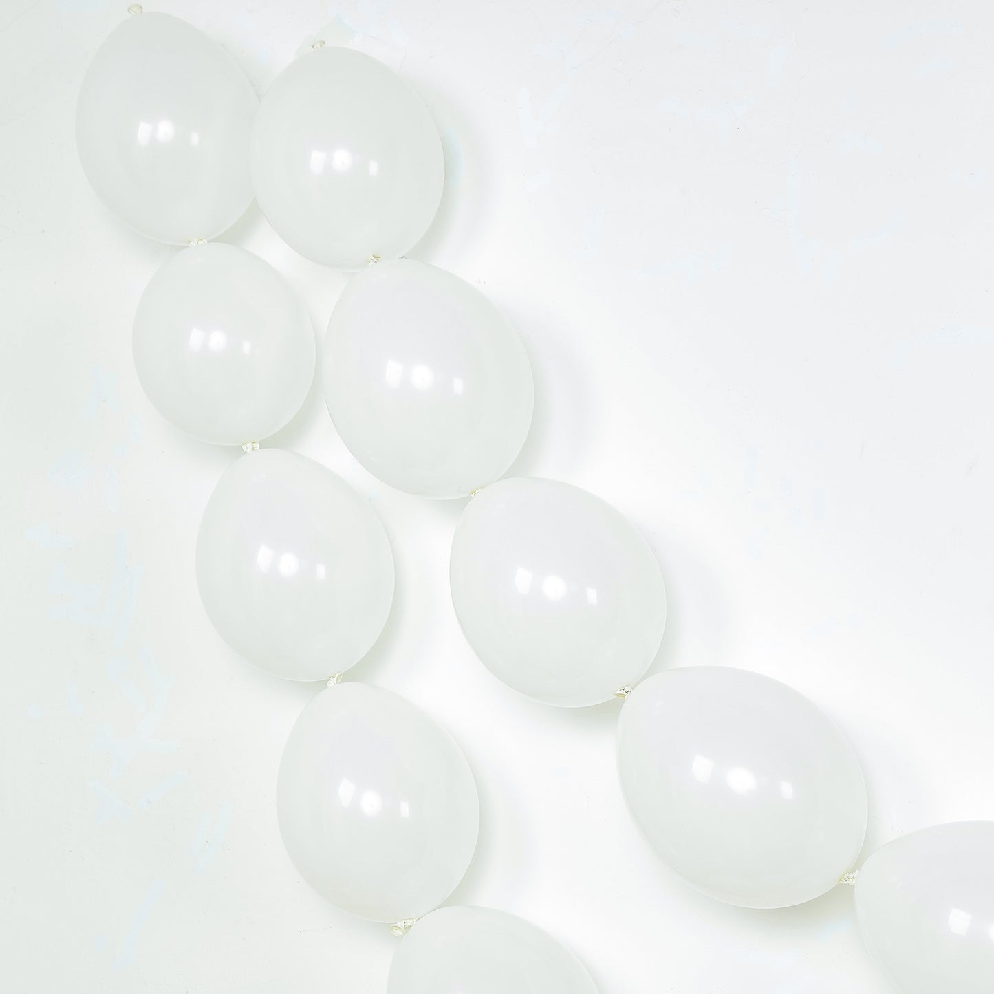 Matte pastel white biodegradable linking balloons in a decorative arrangement.