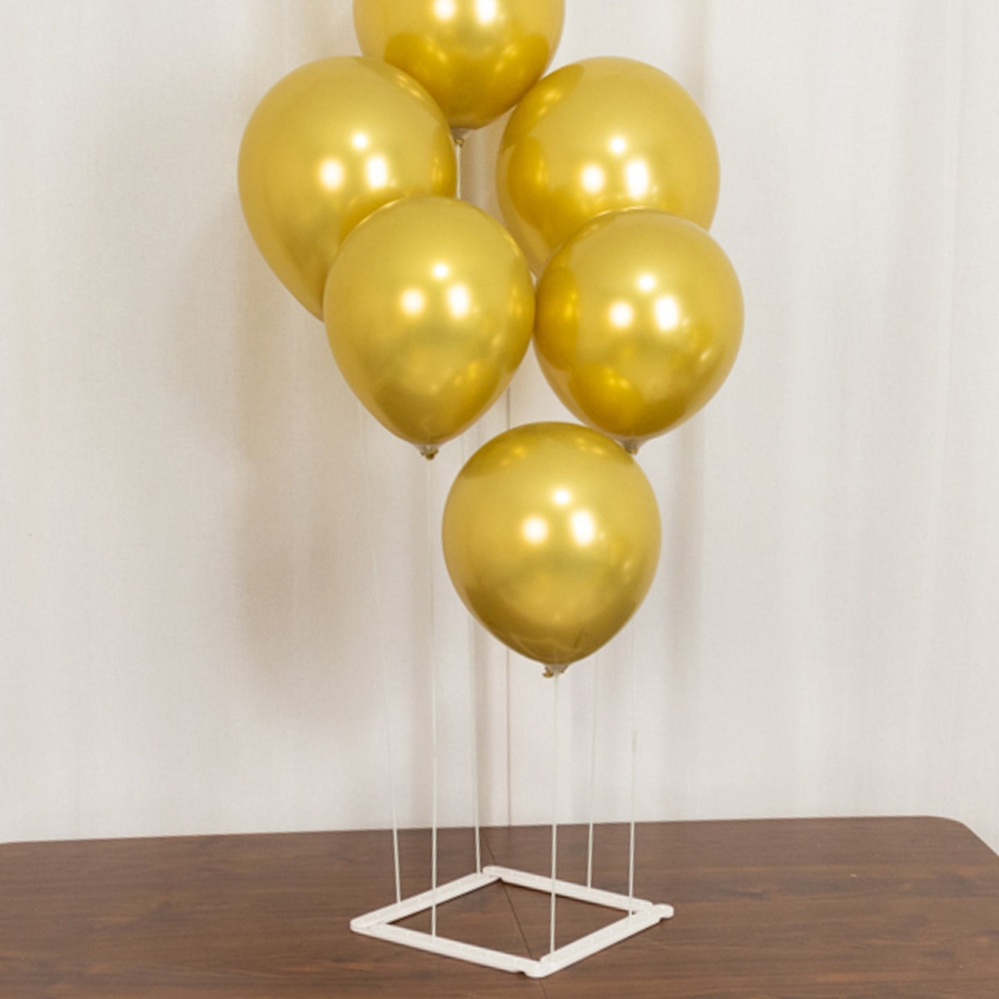 Set of 2 white plastic balloon column stands with gold balloons.