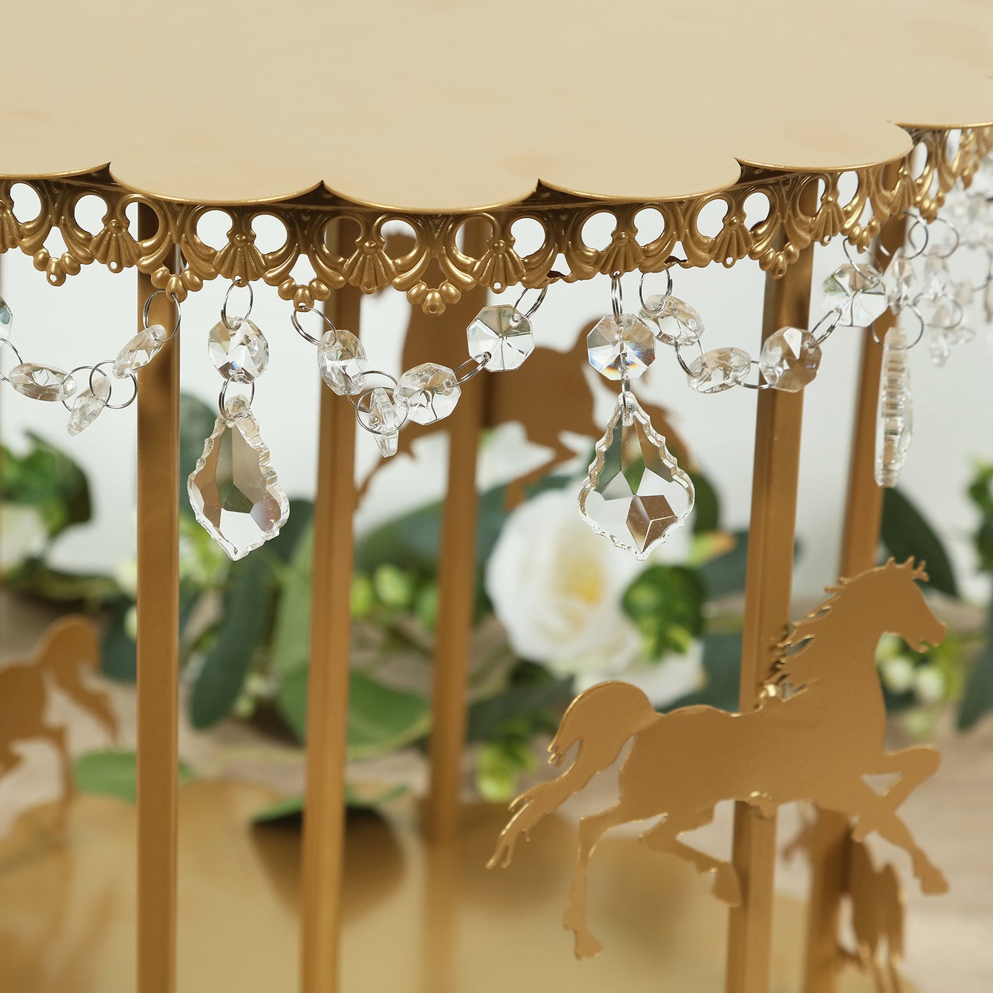 Gold carousel cake stand with hanging acrylic beads and elegant design.