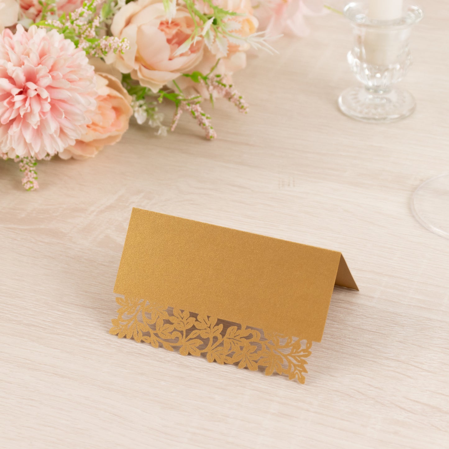 Gold wedding table number card with laser cut leaf vine design.