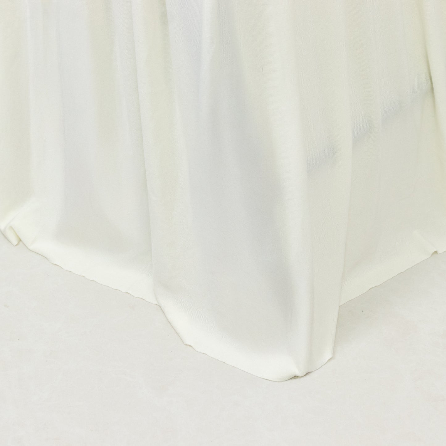 Ivory pleated folding chair cover with floor-length skirt.