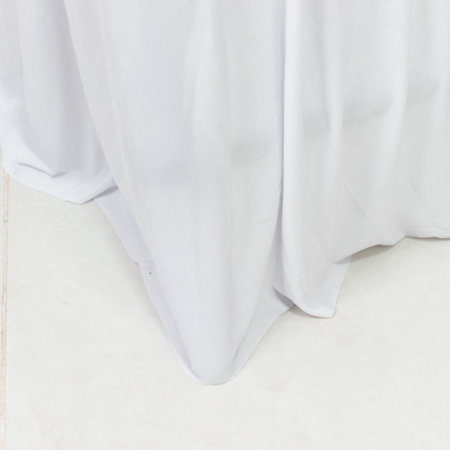 White spandex pleated folding chair cover with floor-length skirt.