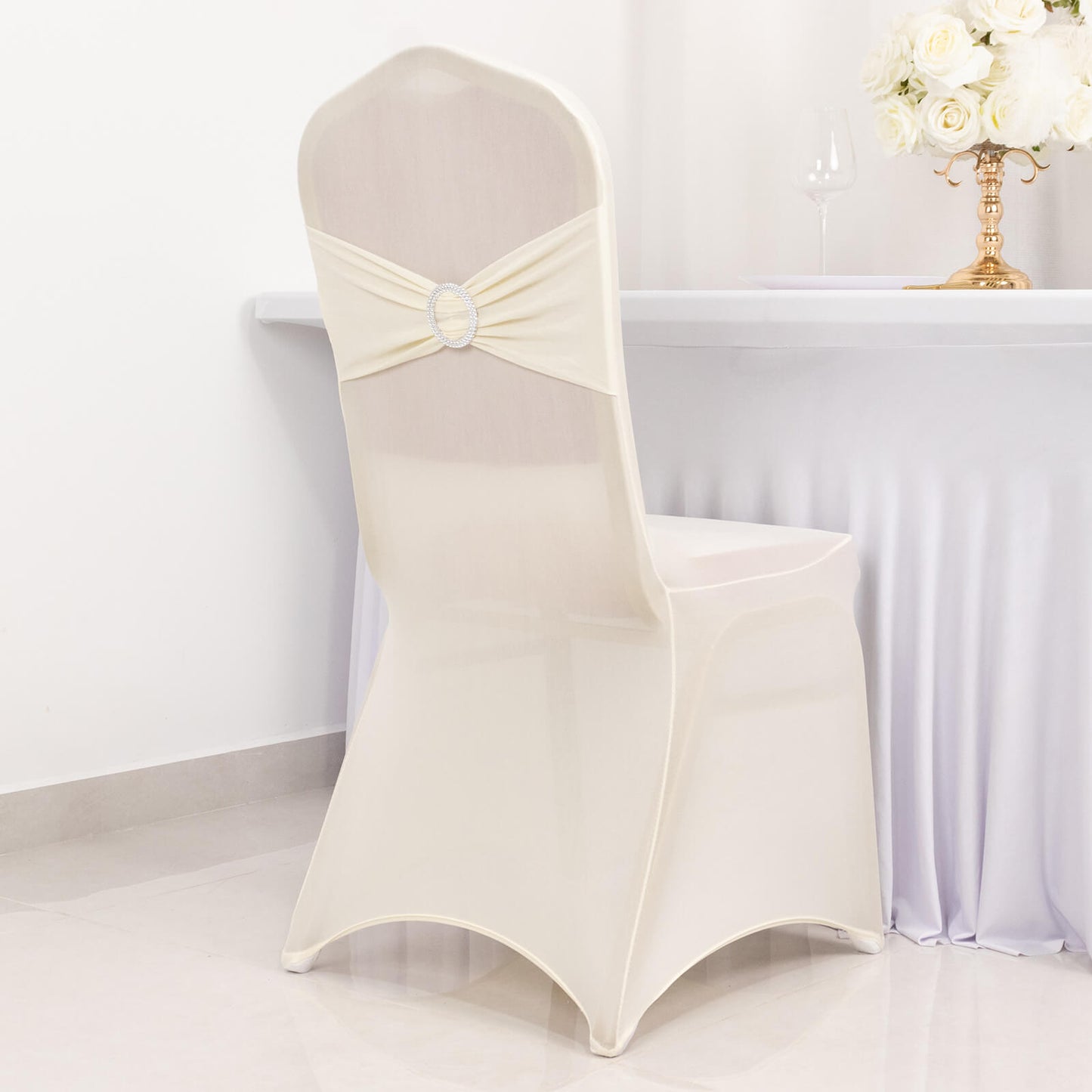 Ivory spandex chair cover with silver rhinestone buckle sash.