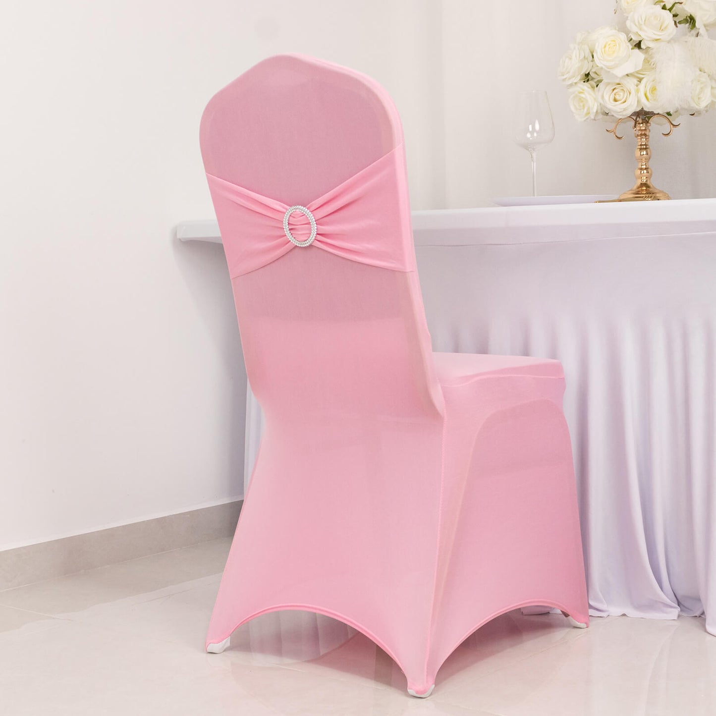 Pink spandex banquet chair cover with silver rhinestone sash.