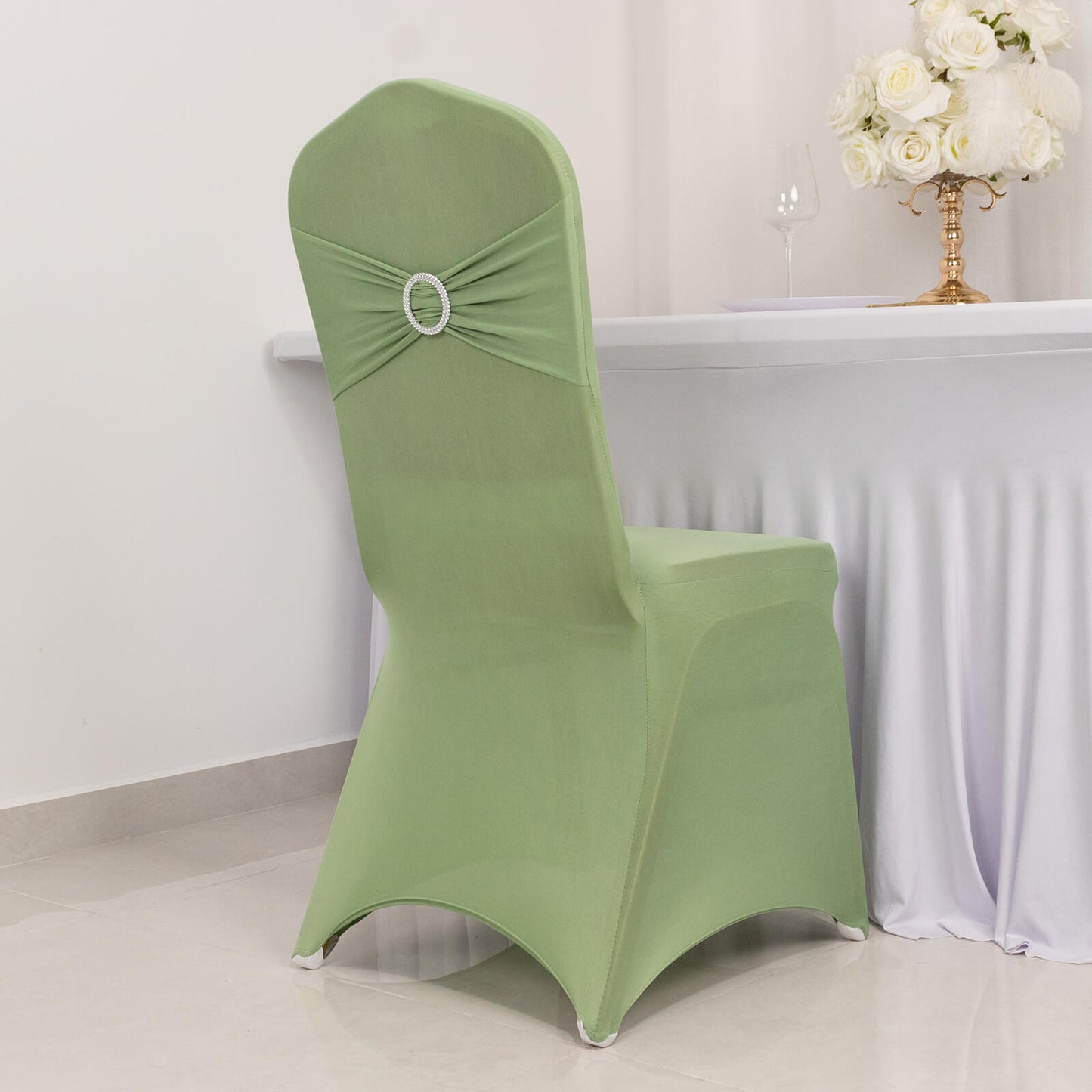 Sage green spandex banquet chair cover with rhinestone sash.
