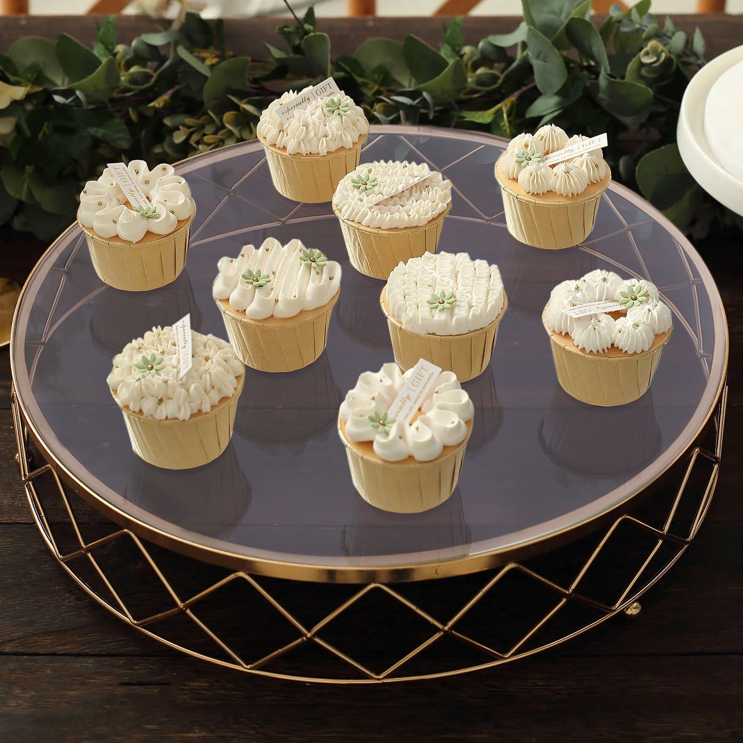 Gold geometric cake stand displaying decorative cupcakes.