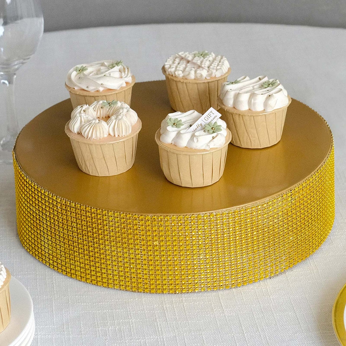 Gold rhinestones round metal pedestal cake stand displaying cupcakes.
