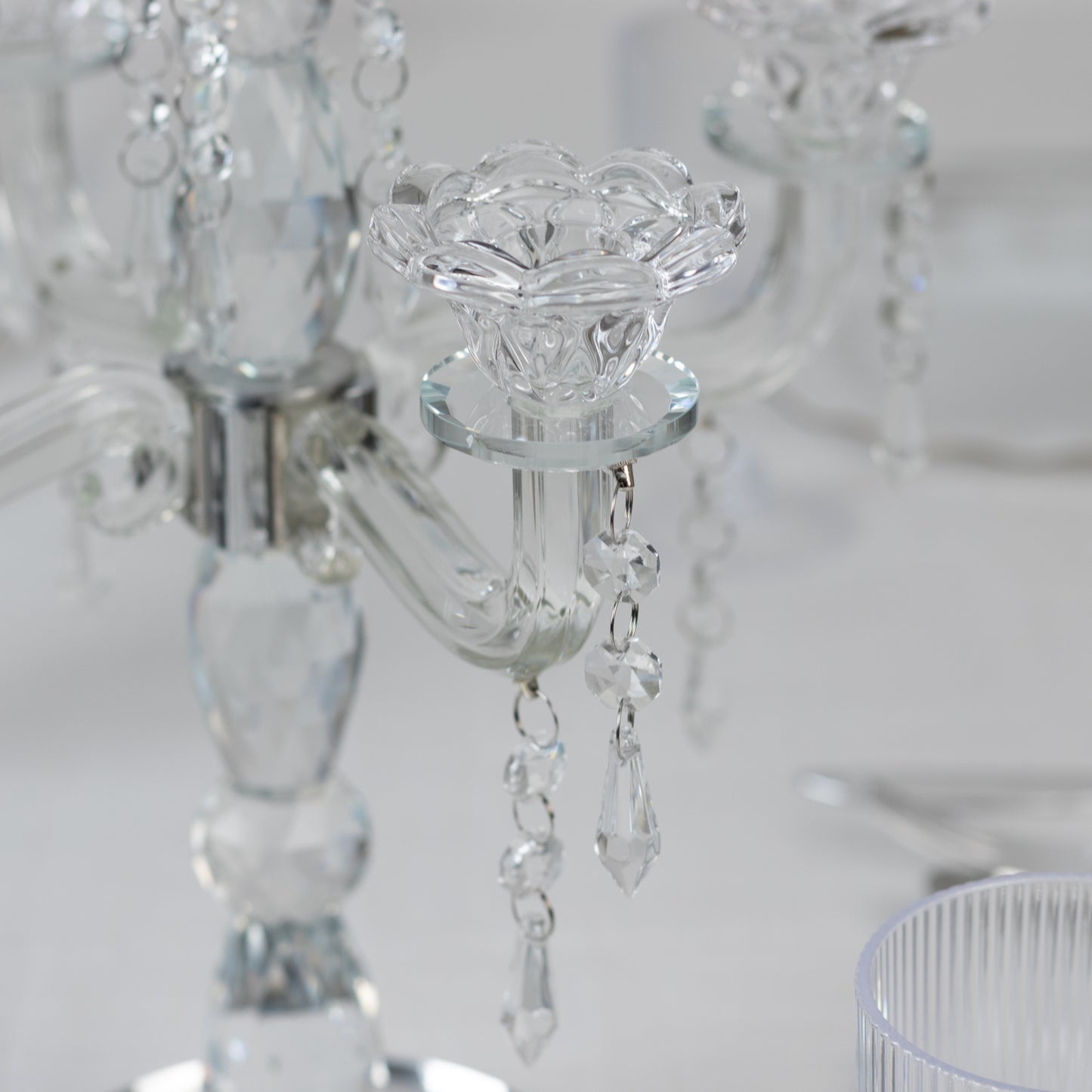Clear crystal taper candle holder with five arms and elegant hanging pendants.