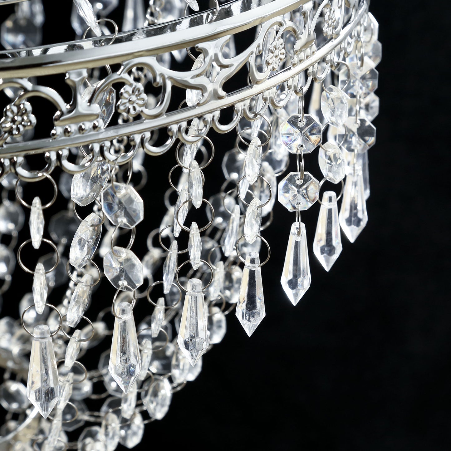 Silver beaded crystal chandelier with ornate metal frame.