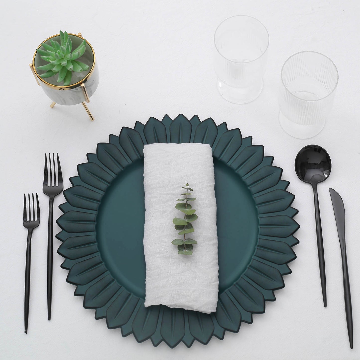 Matte teal sunflower disposable charger plate with a napkin and greenery.