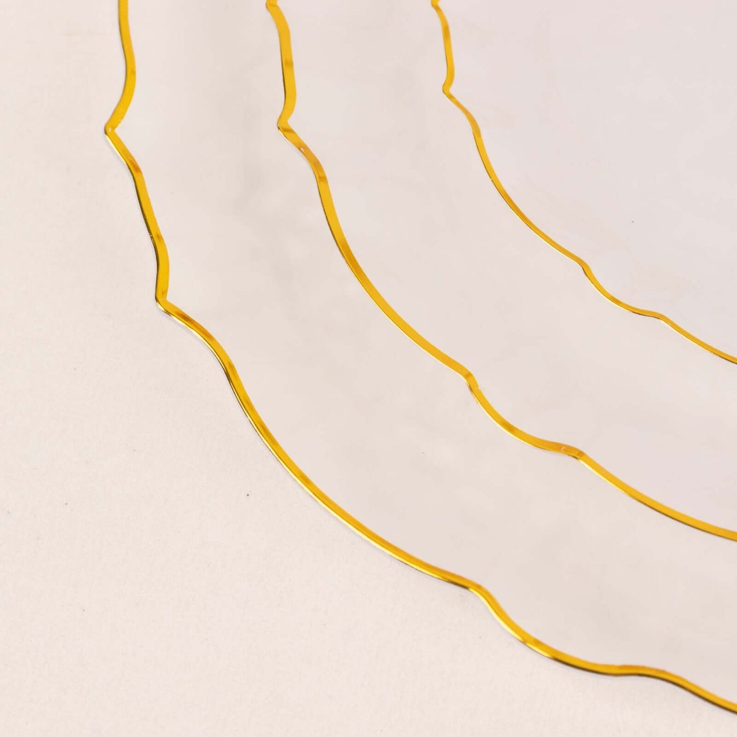 Clear plastic charger plate with gold scalloped rim.