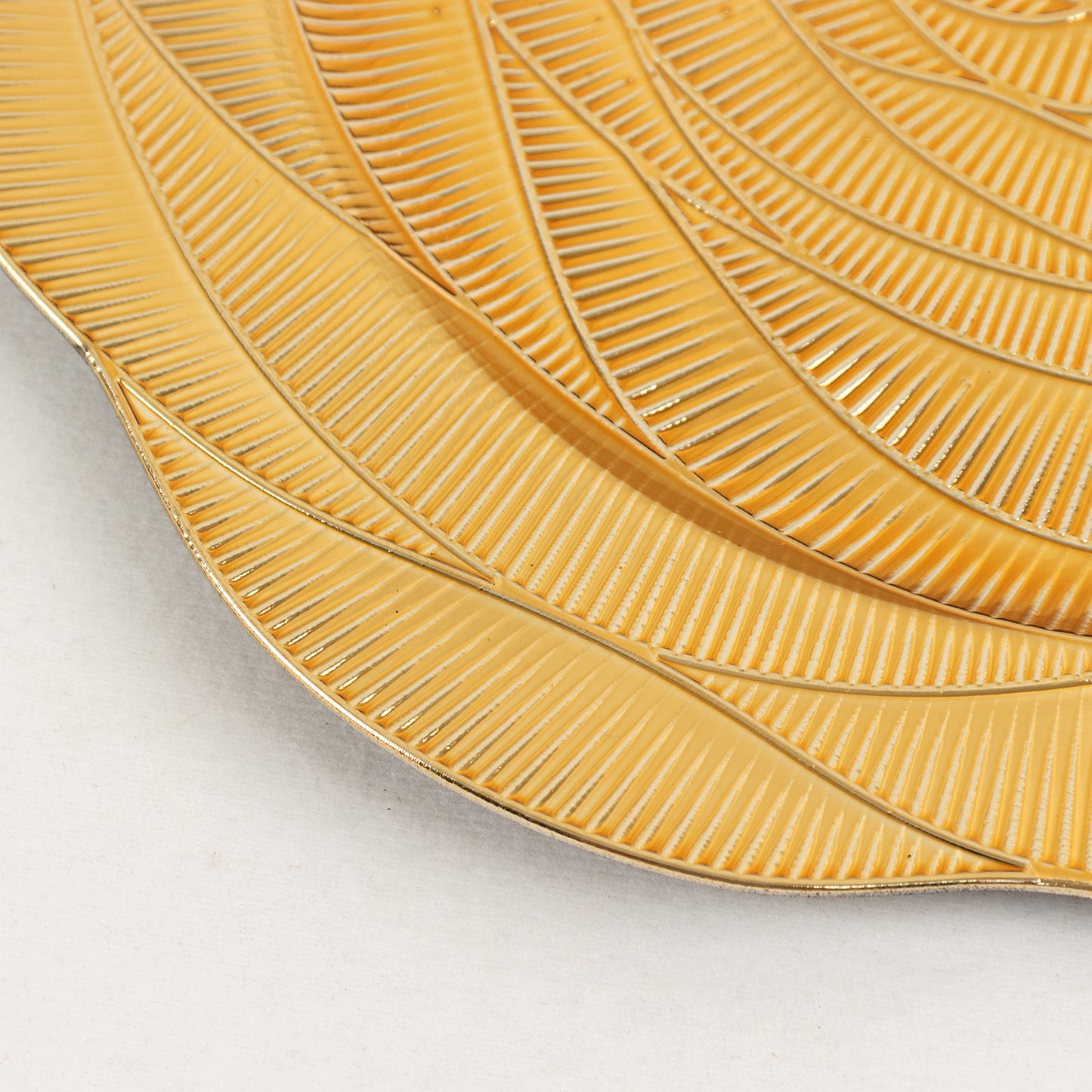 Metallic gold charger plate with ribbed design, perfect for elegant table settings.