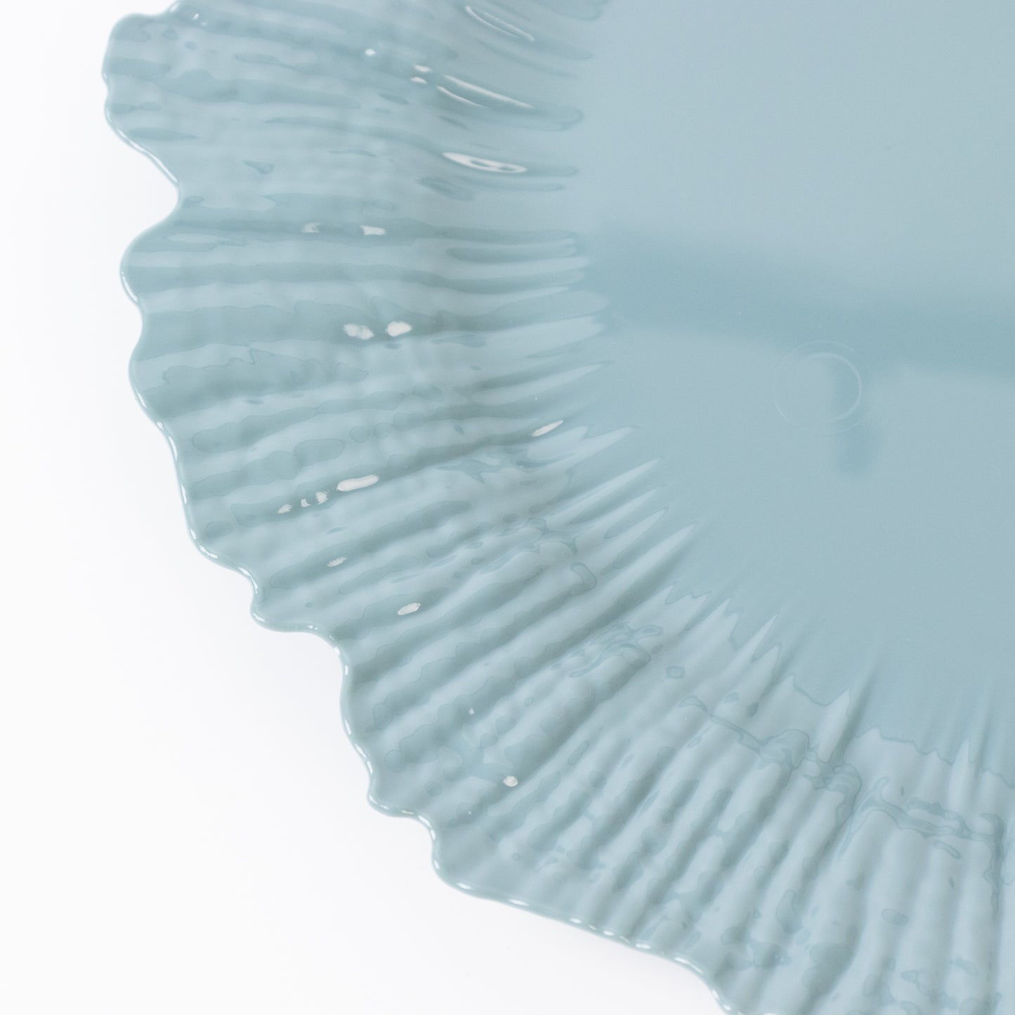 Dusty blue plastic charger plate with a textured edge.
