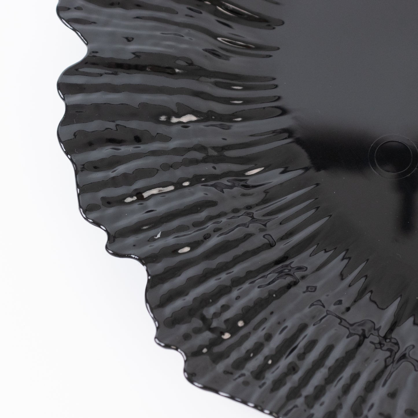 Black charger plate with a decorative edge for events and dining.
