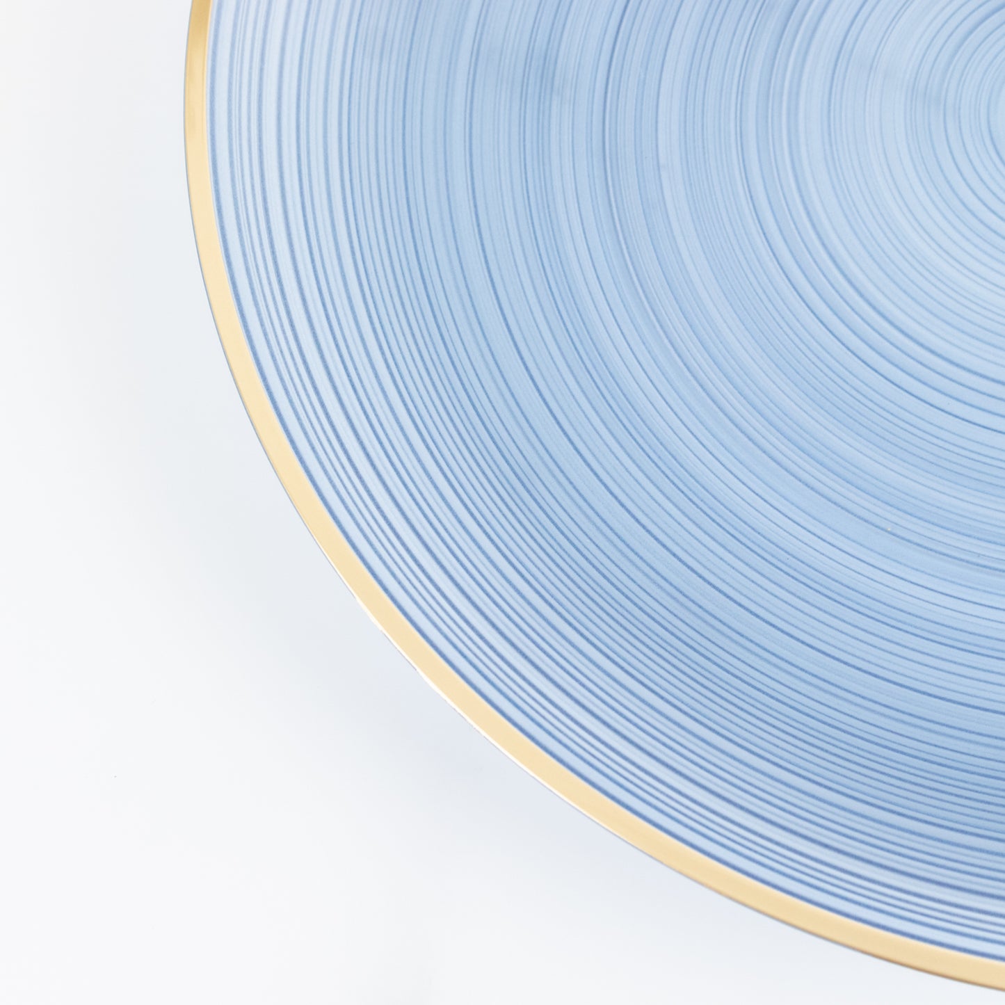 Transparent dusty blue swirl charger plate with gold rim.