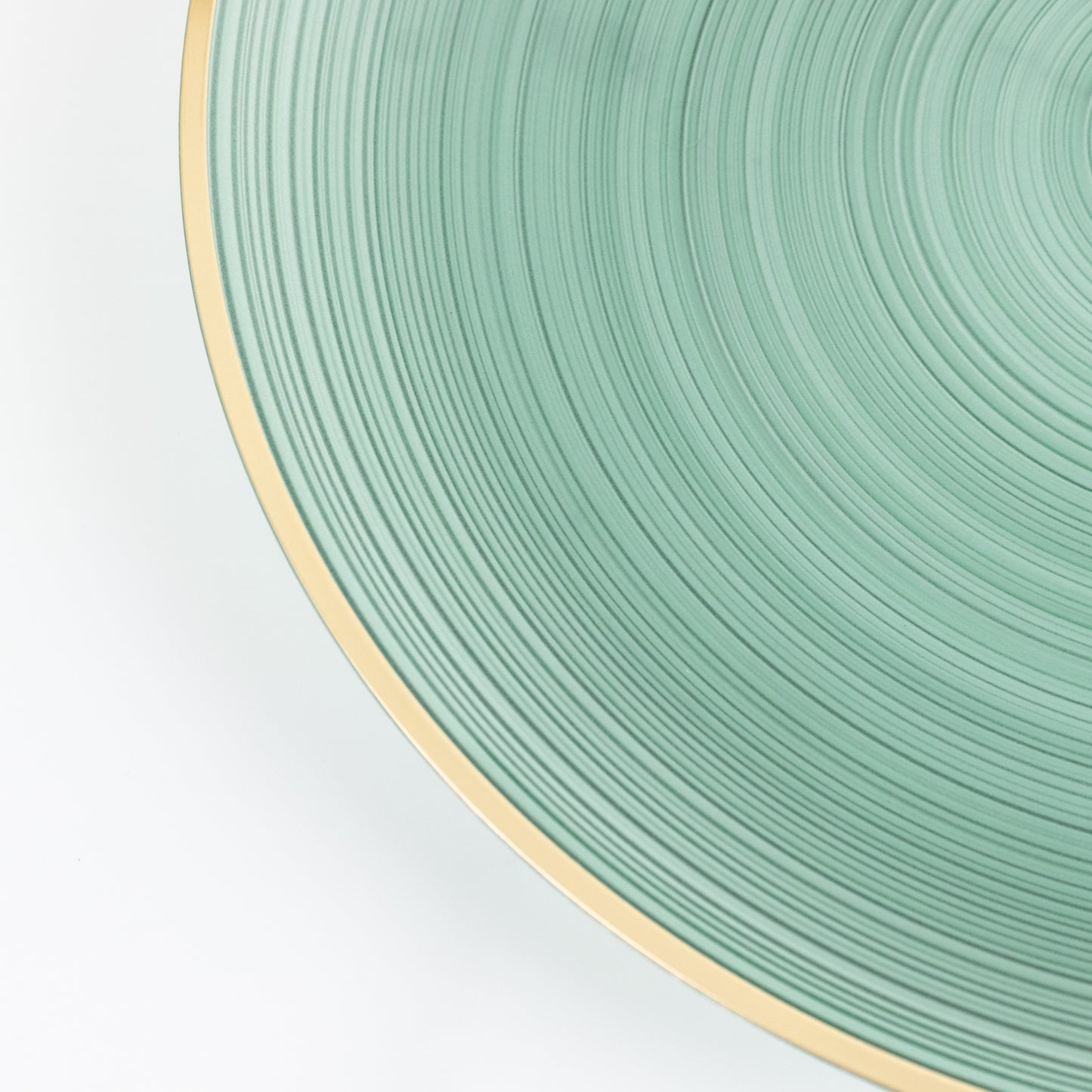 Transparent dusty sage green swirl charger plate with gold rim.
