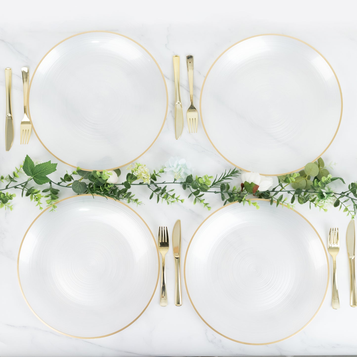 Transparent pearl white swirl charger plates with gold rim.