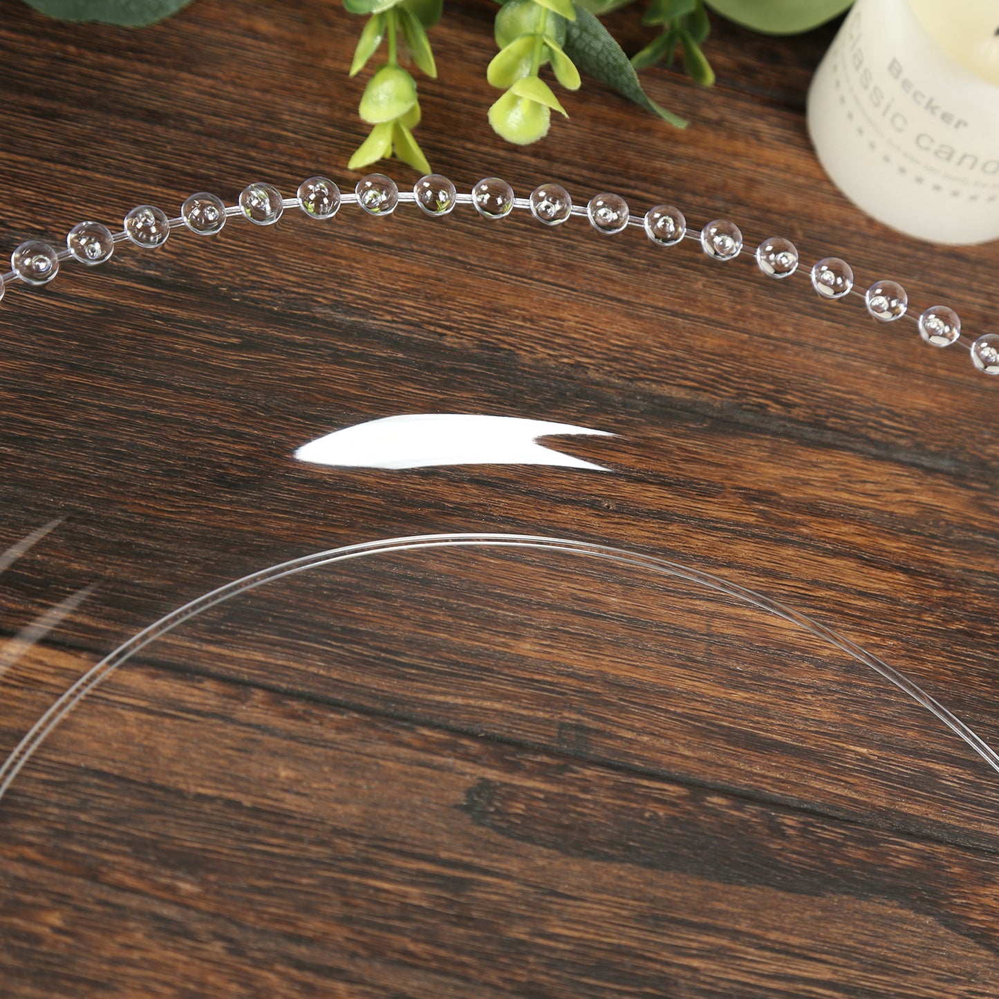 Clear beaded rim plastic charger plate on wooden table.