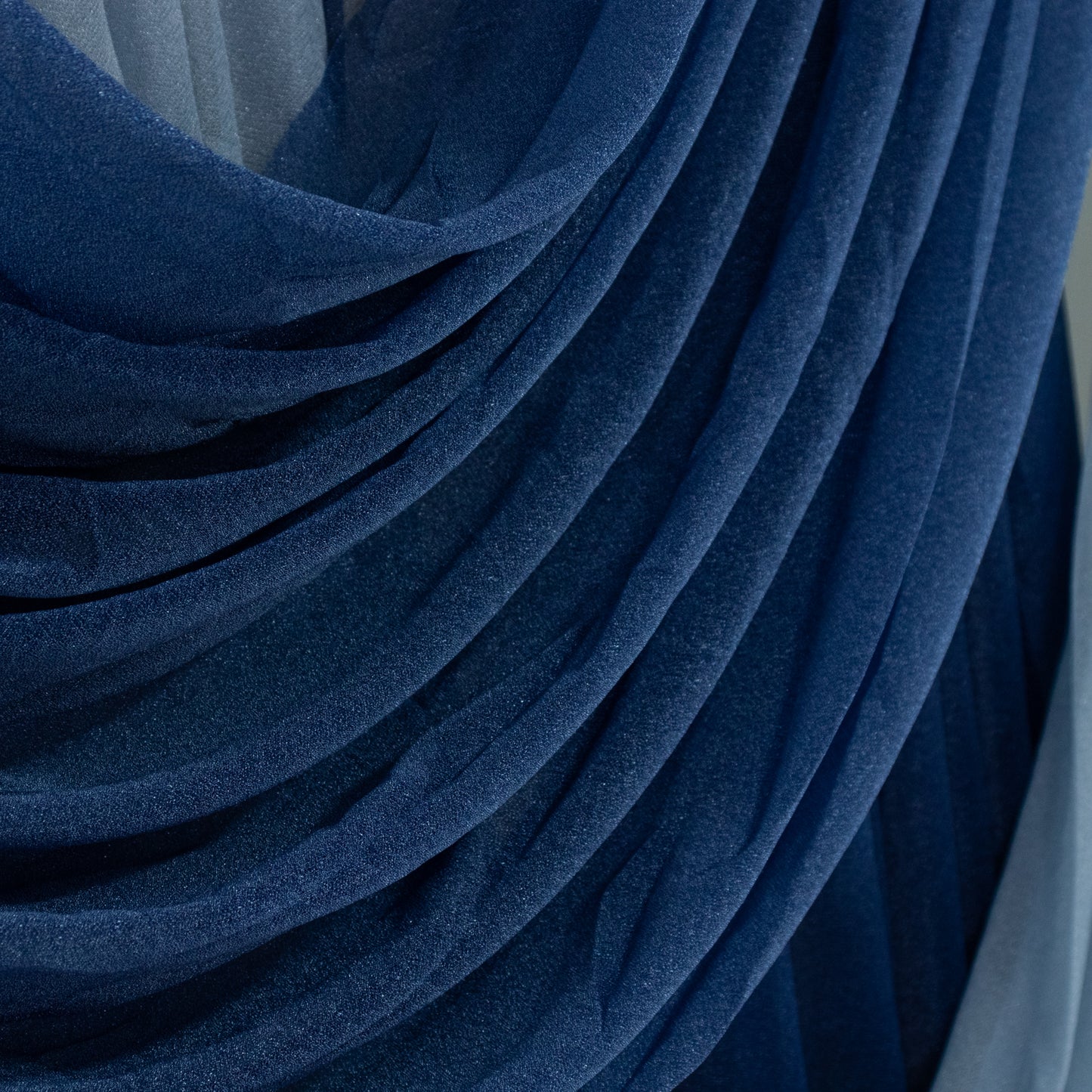 Navy blue sheer chiffon backdrop valance drapes with curved swag design.