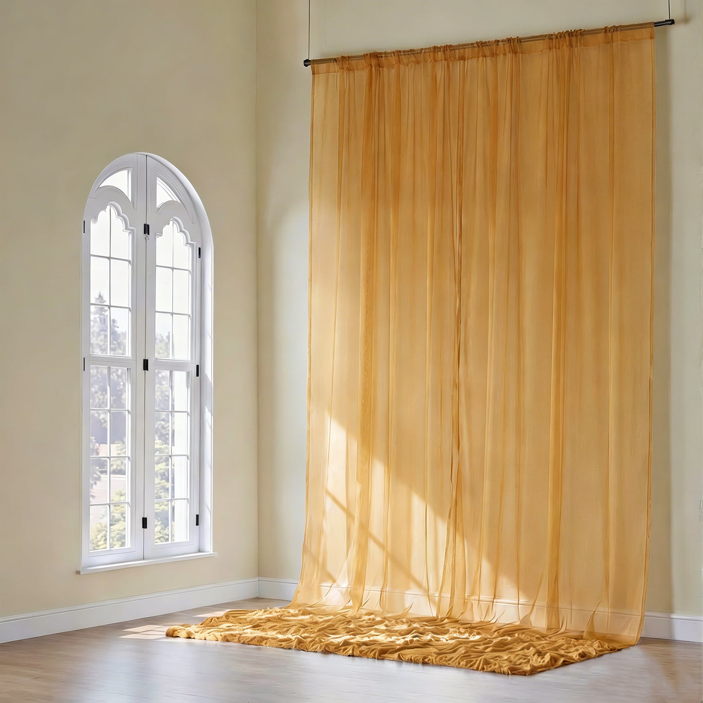 Gold chiffon curtain panel drape in a bright interior setting.
