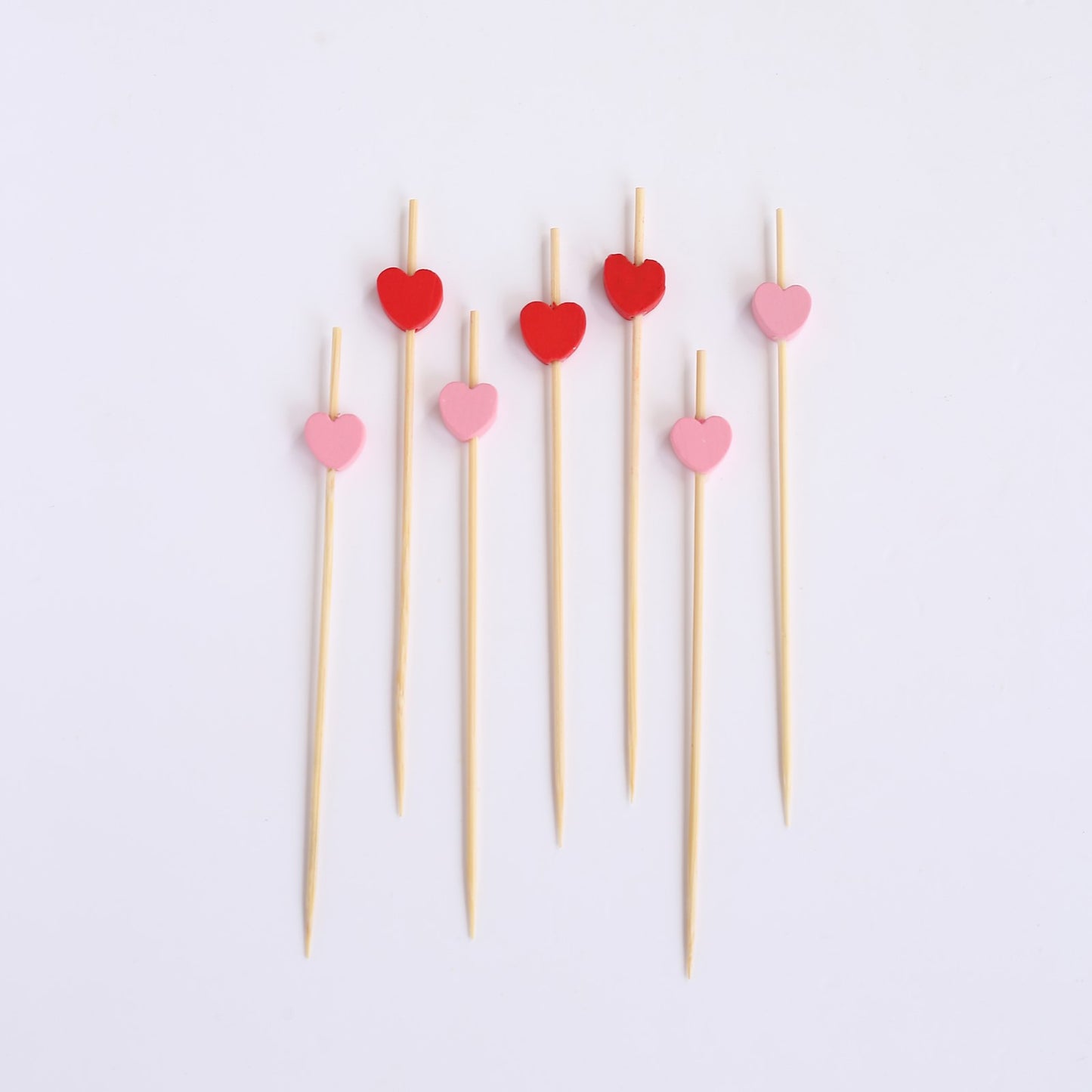 Red and pink eco-friendly bamboo heart skewers, perfect for parties.