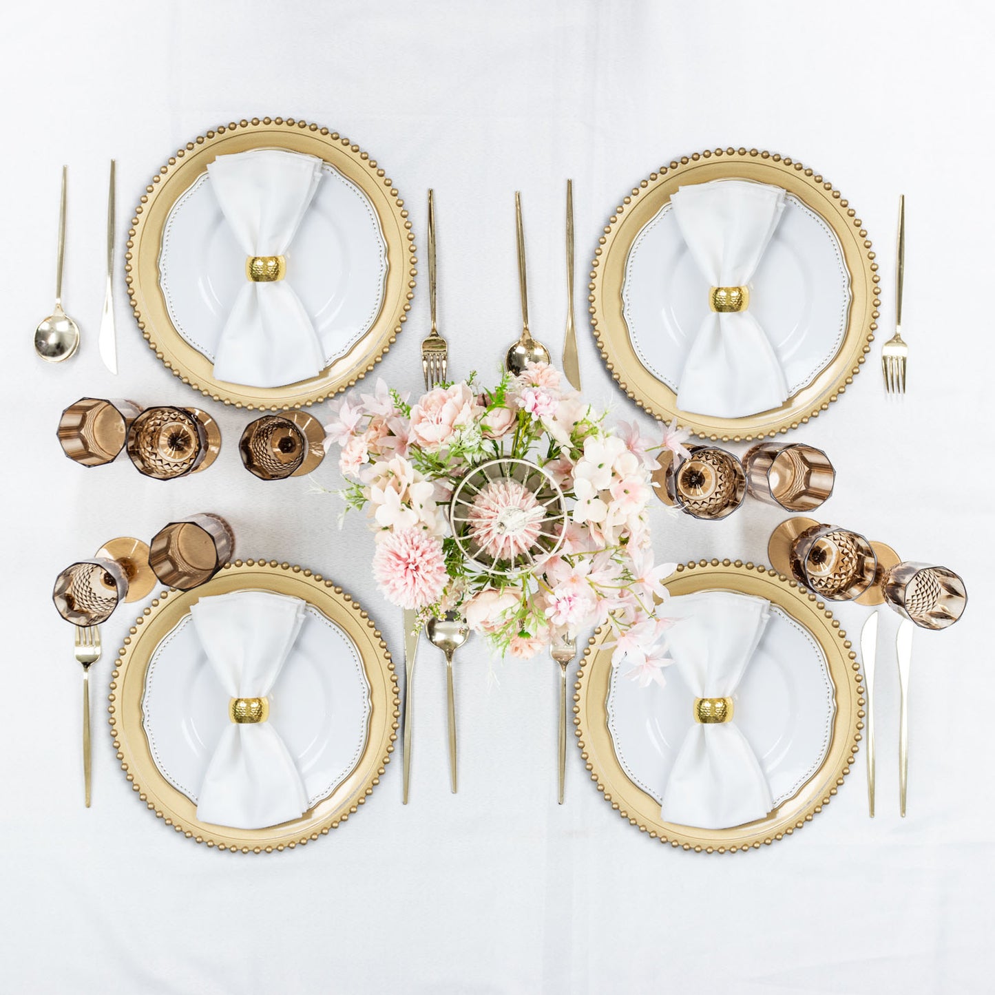 Amber gold reusable plastic wedding flute glasses arranged elegantly on a table setting.