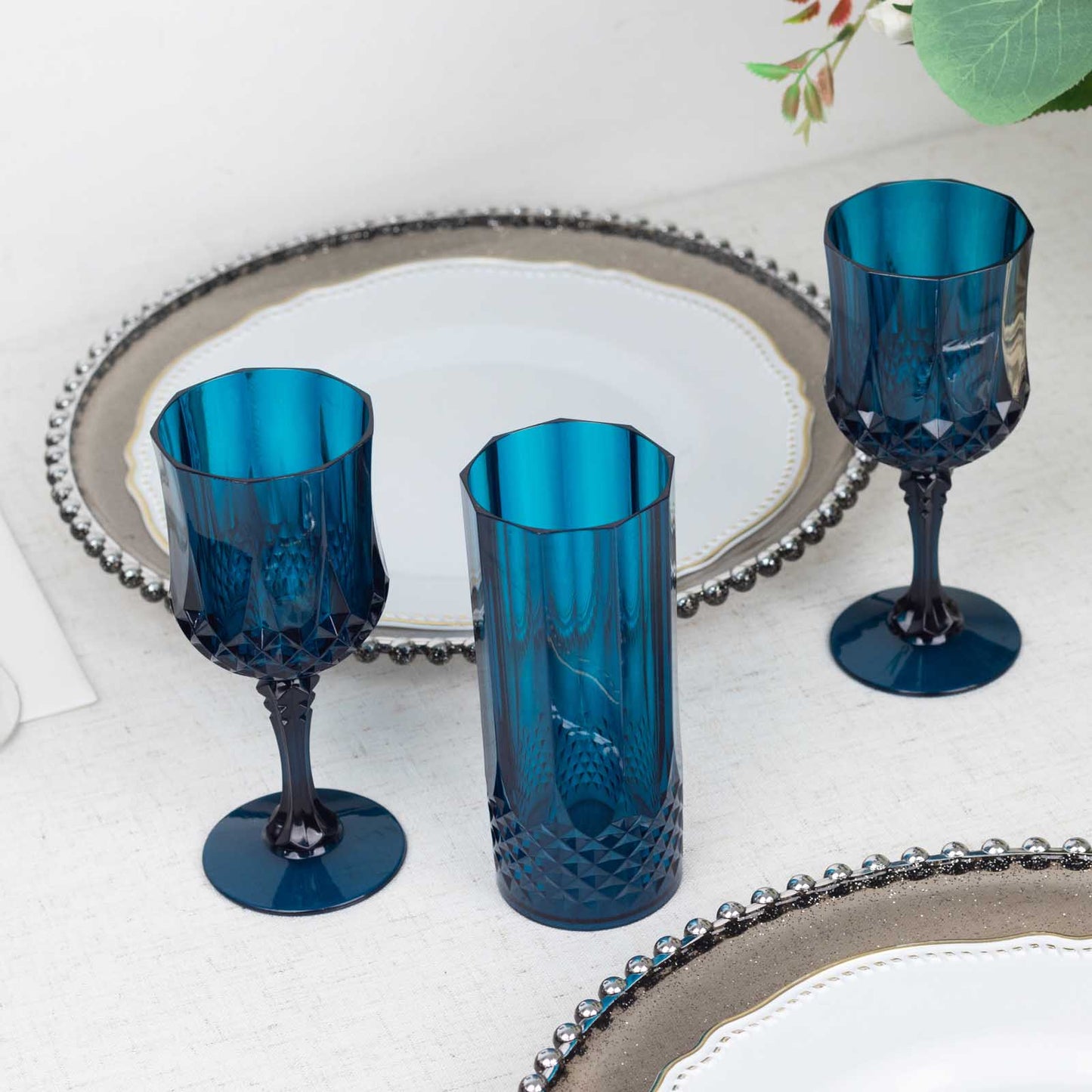 Navy blue reusable plastic cocktail goblets on a table setting.