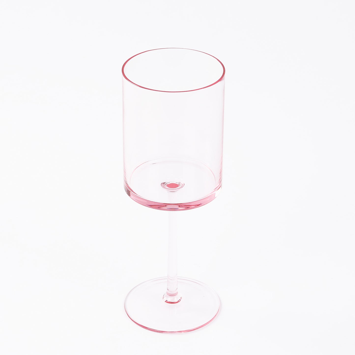 Transparent blush plastic reusable cocktail glass with long stem.