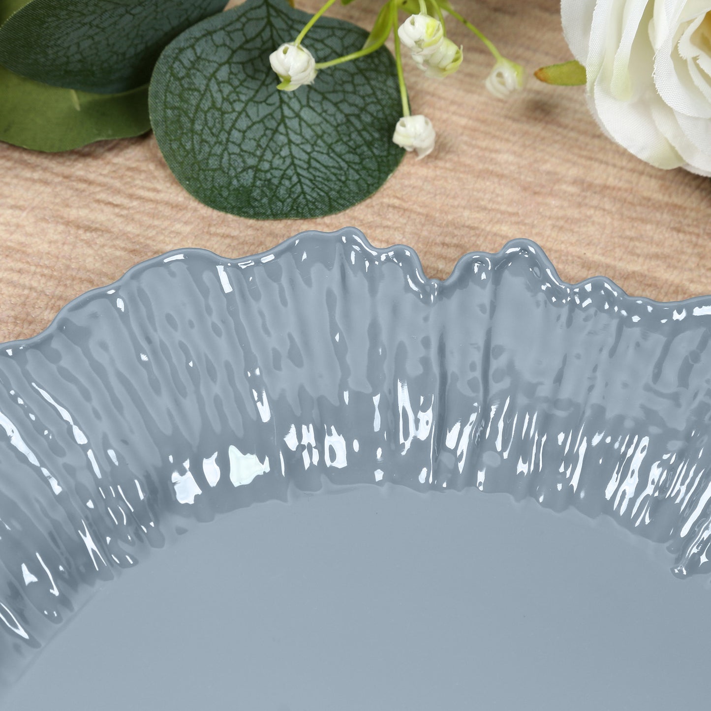 Dusty blue reef design plastic dinner plate on a wooden table.
