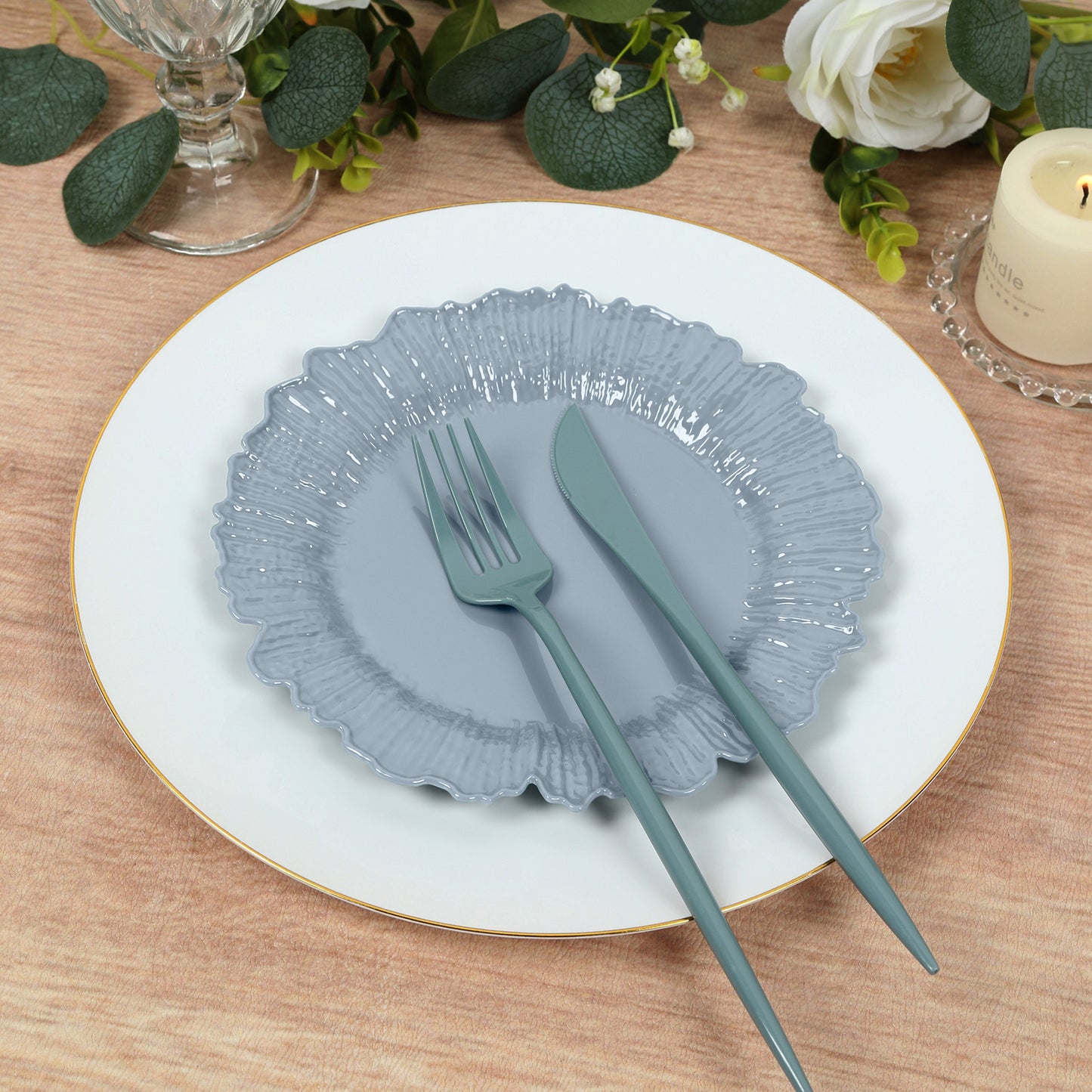 Dusty blue reef design plastic dessert plates stacked on a table setting.