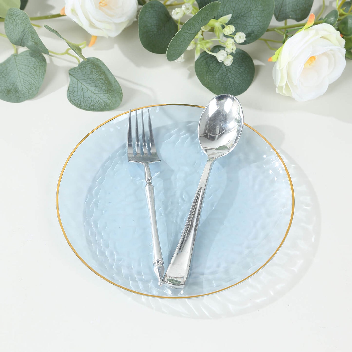 Transparent dusty blue hammered plastic plate with gold rim.