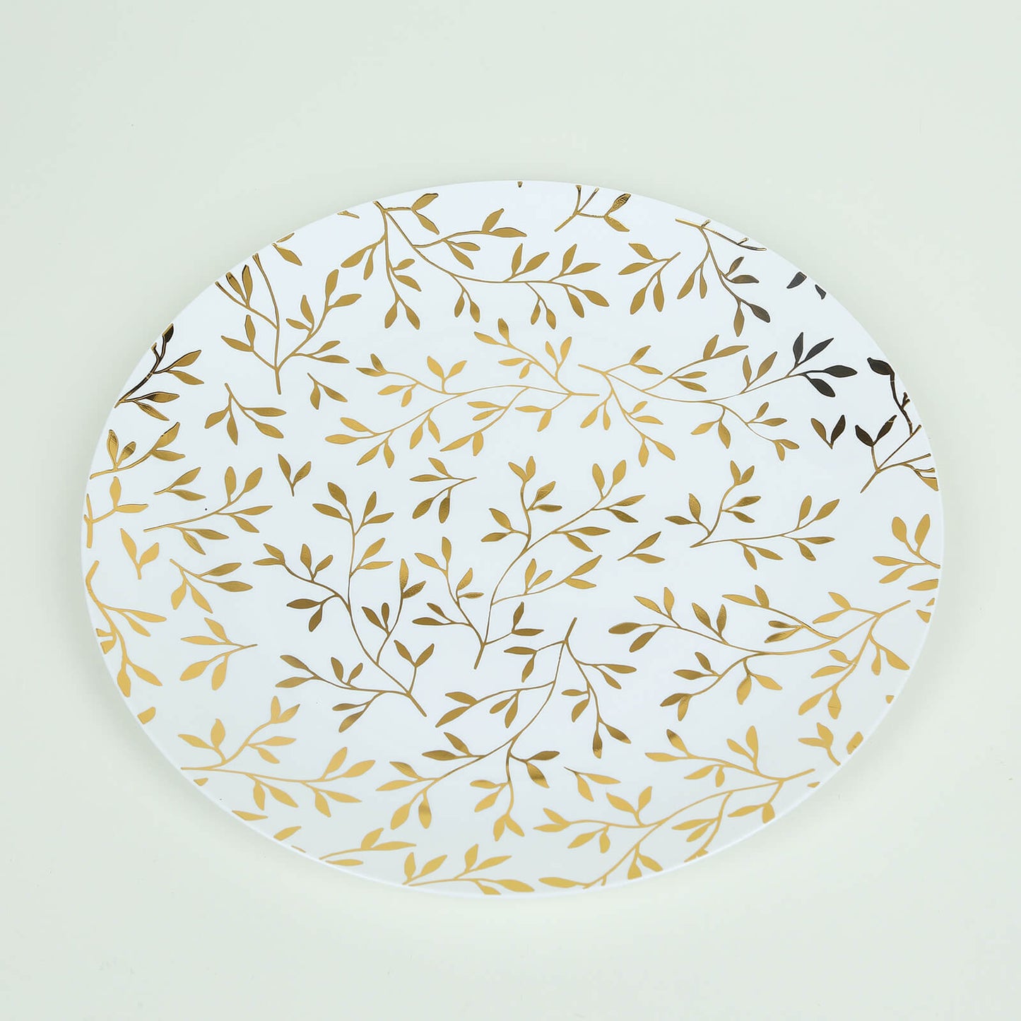 White round plastic party plate with gold leaf design.