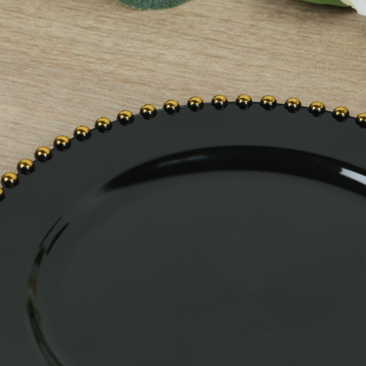 Black round dinner plate with gold beaded rim, perfect for festive occasions.