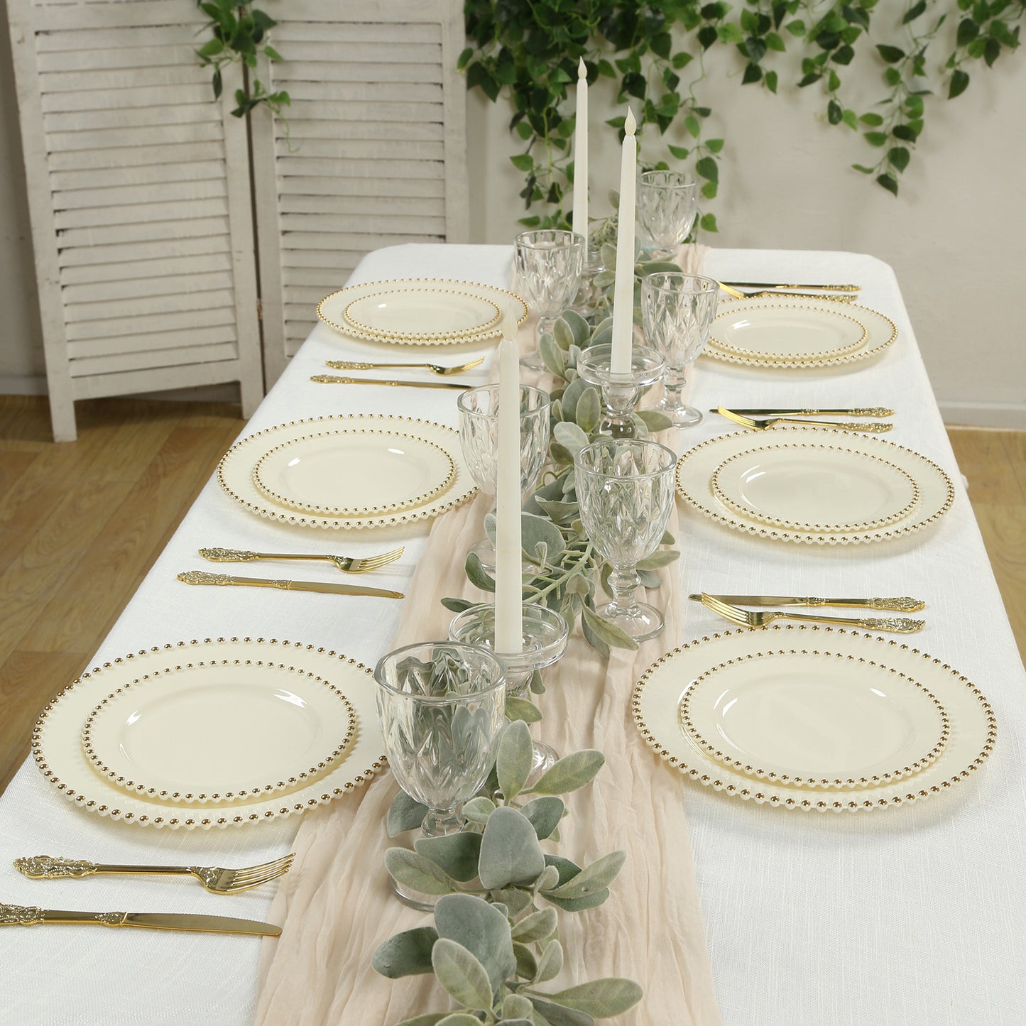 Ivory round dinner plates with gold beaded rim on a festive table setting.