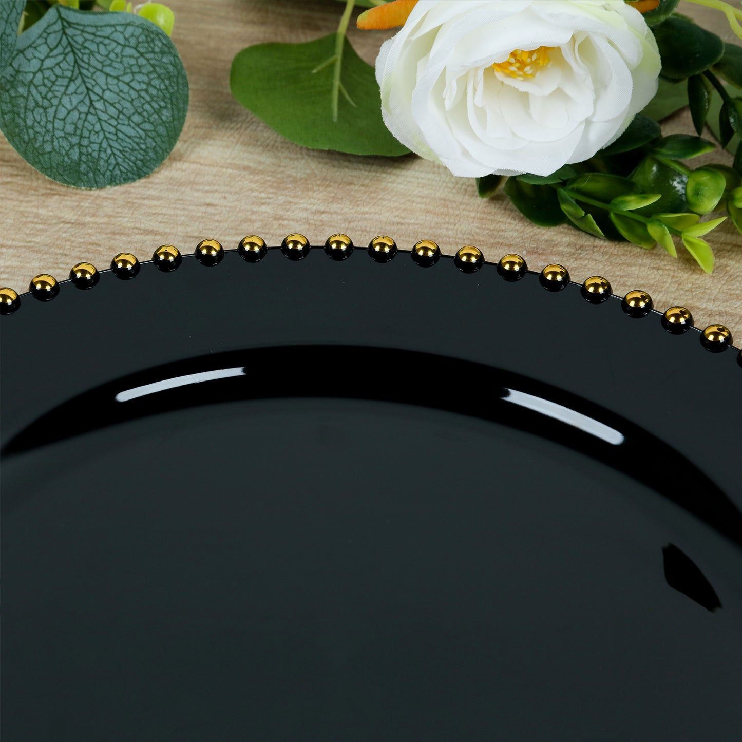 Black plastic dessert plate with a gold beaded rim, 8 inches round.