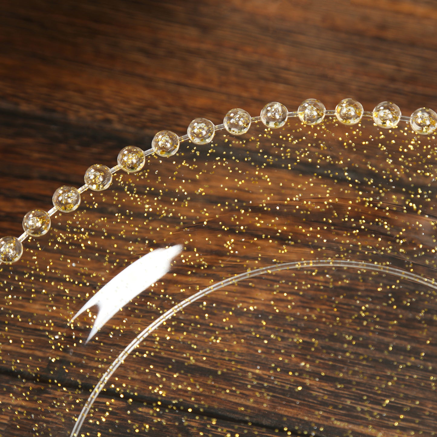 Clear gold glittered plastic dessert plate with a beaded rim.