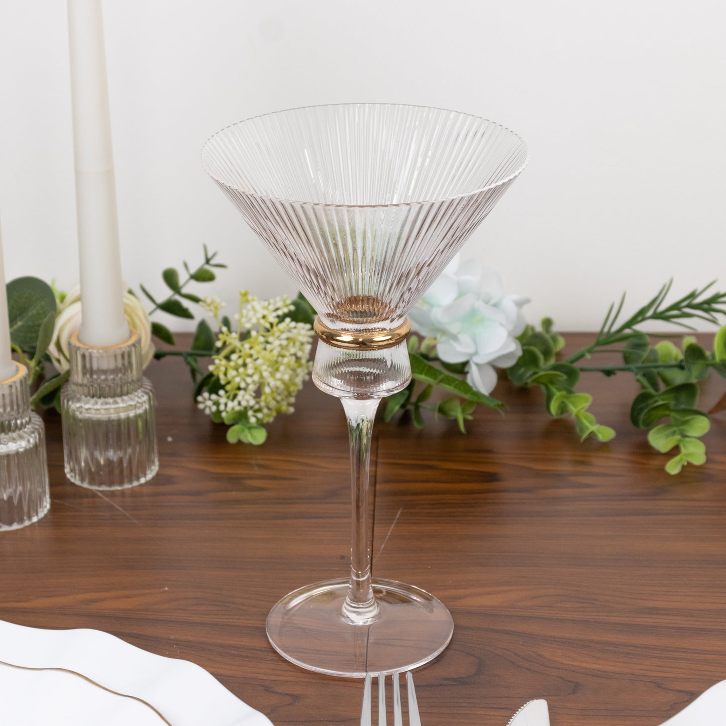 Clear martini glass with ribbed design and gold ring accent.