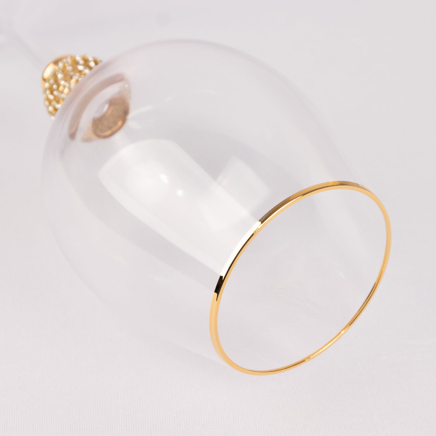 Gold rimmed crystal wine goblet glass with rhinestone studded stem.