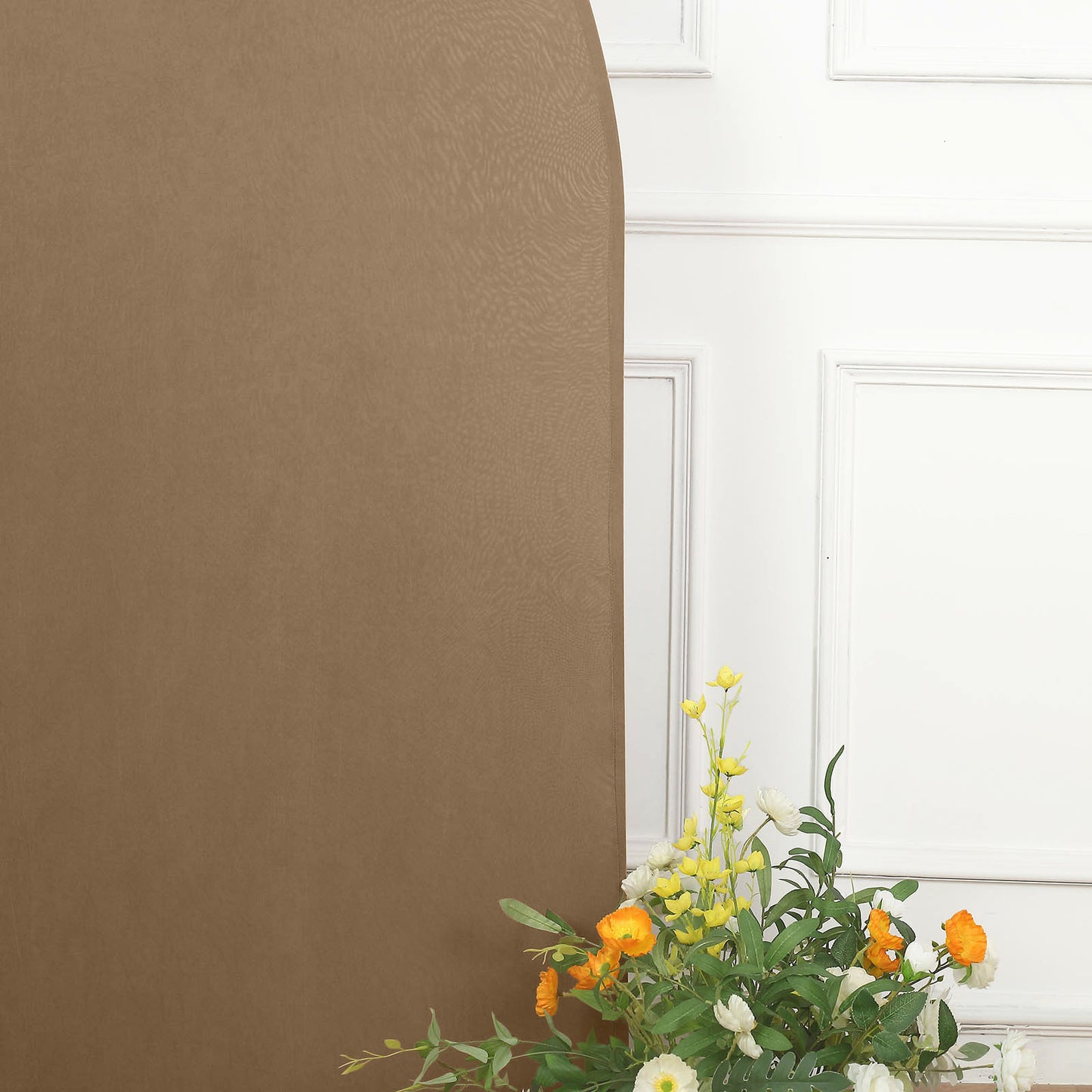 Matte taupe half moon wedding arch cover with floral arrangement.
