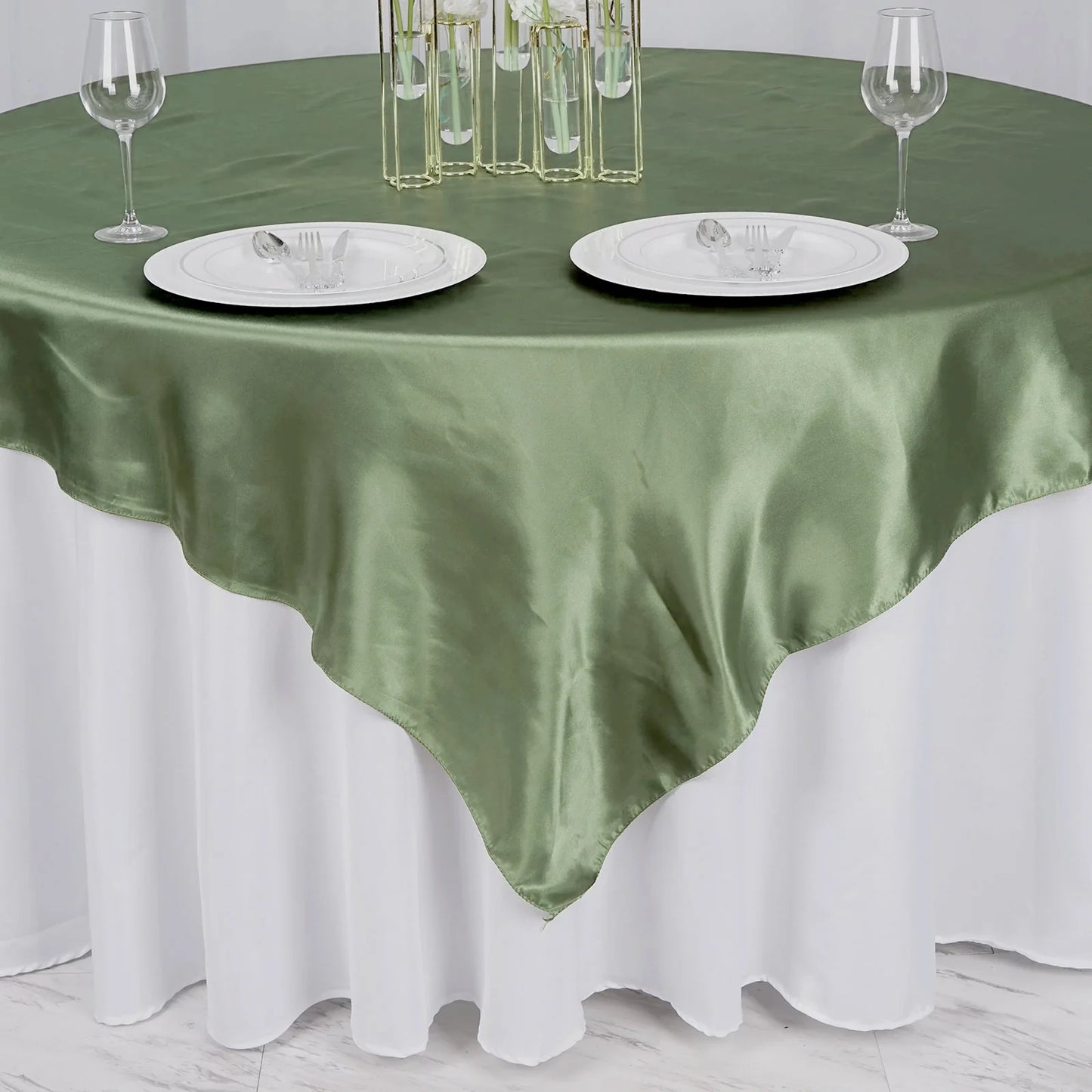Dusty sage green satin table overlay on a round table setting.
