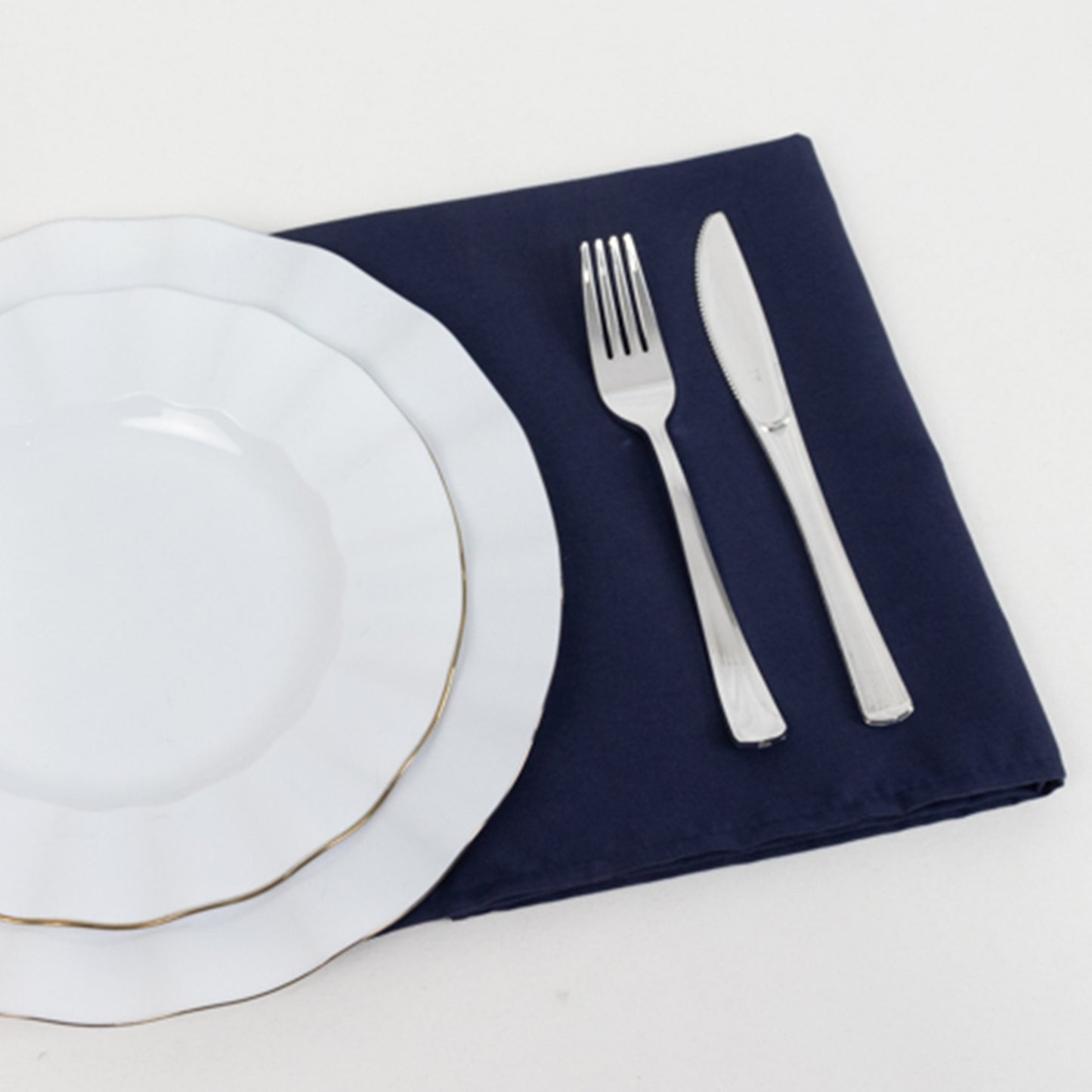 Navy blue cotton blend cloth napkin with white plates and silver utensils.