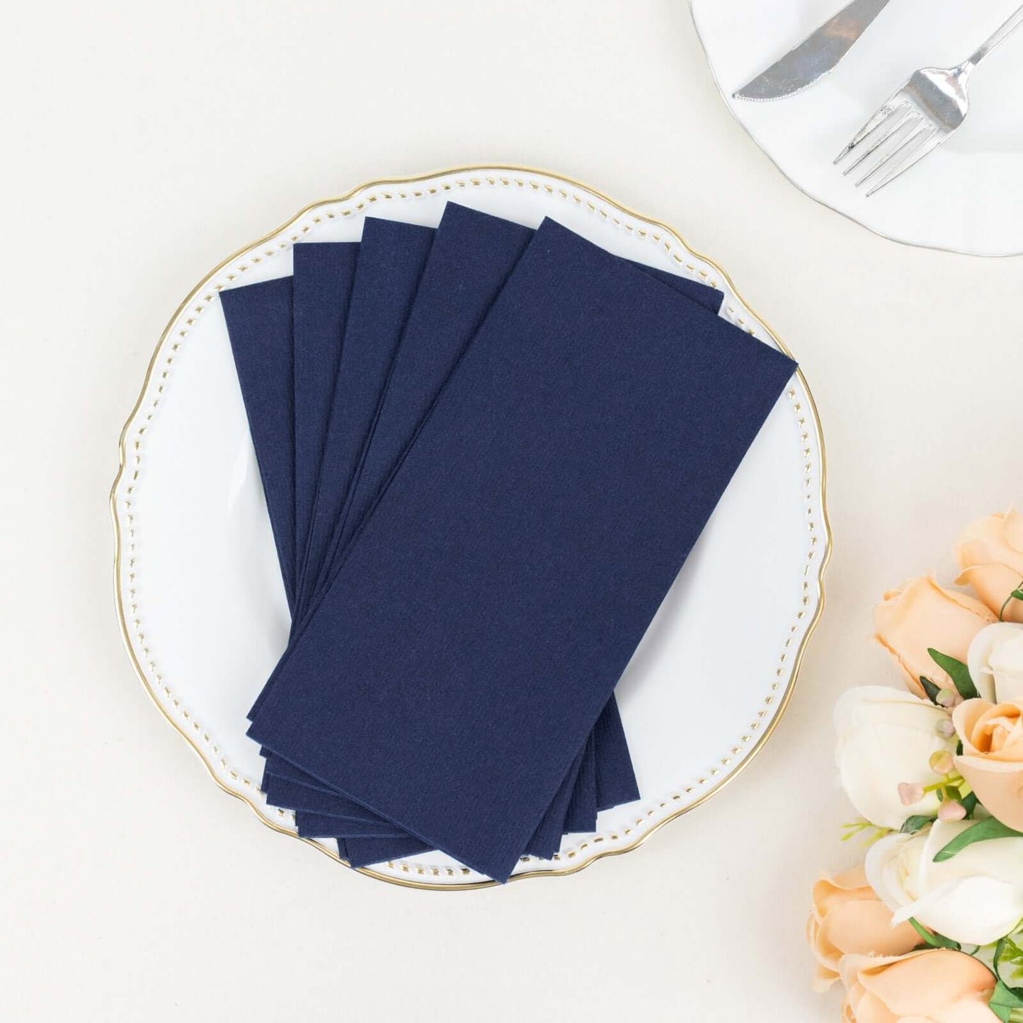 Navy blue linen-feel paper napkins on a decorative plate.